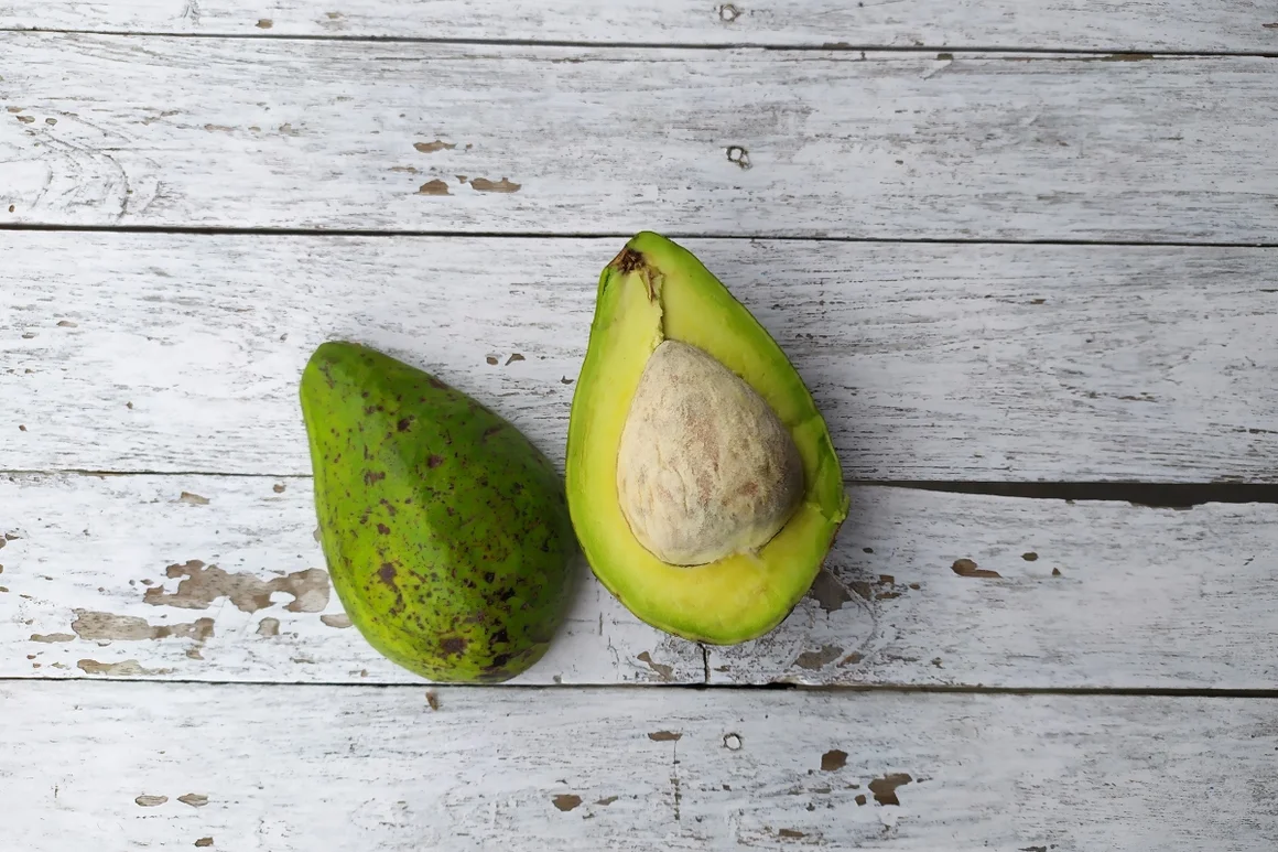 Zwei Hälften einer Avocado auf einer Holzplatte